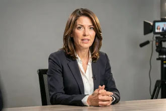 Journaliste française en blazer sombre lors d'une interview télévisée en studio
